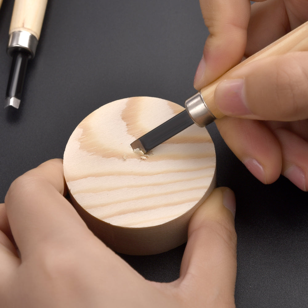 Hand using a Woodworking Carving Knife Tool from the 5 PCS set to carve a circular wooden block, showcasing precision and control.