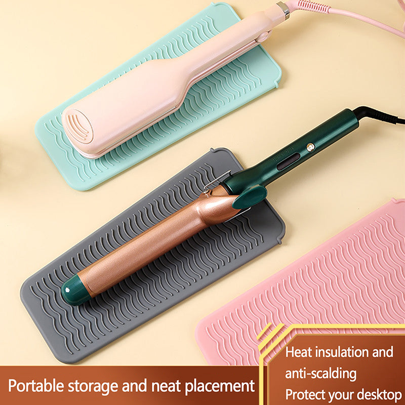 Hot Styling Tool Mat for Hair Tools in pink, gray, and teal colors with curling irons placed on top, offering heat protection for surfaces.