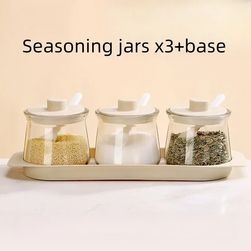 3PCS Glass Seasoning Storage Bottles Set on tray with sesame, salt, and herbs, perfect for kitchen spice organization at Bamagate.com.