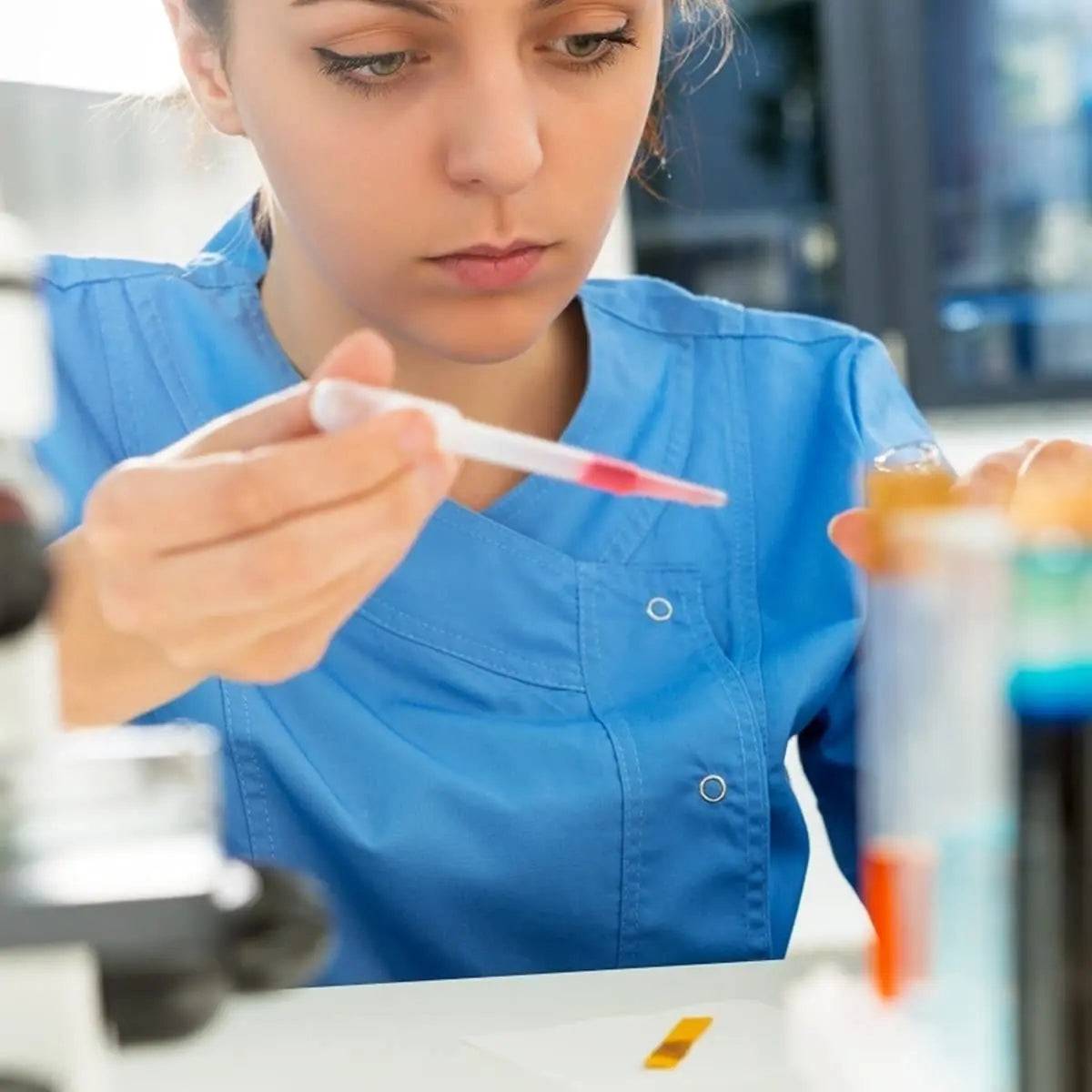 Artist using a 3ml plastic painting dropper to dispense red liquid, demonstrating precision in arts and crafts projects.