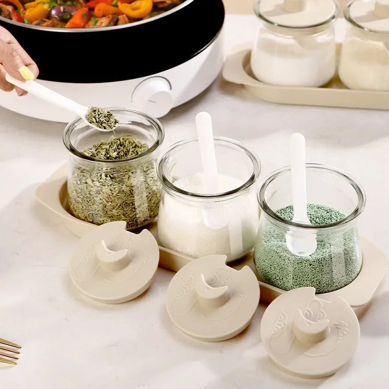 3PCS Glass Seasoning Storage Bottles Set with removable lids and spoons, displayed on a countertop for efficient spice access and storage.
