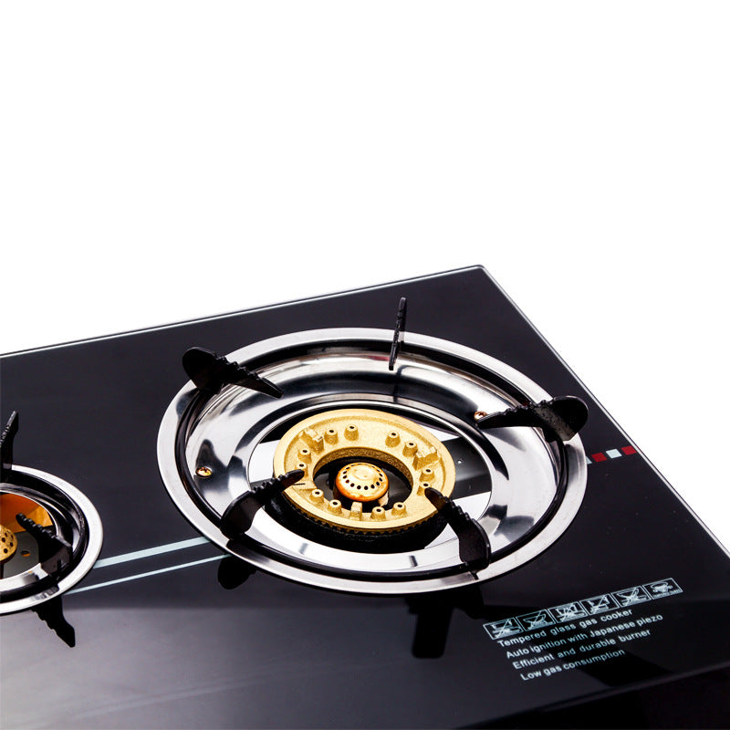 Close-up of CAMY gas cooker's brass burner on a sleek black glass top, showcasing durable design and efficient flame control.