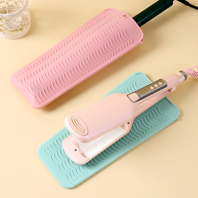 Hot Styling Tool Mat in pastel colors used under a hair straightener, protecting countertops from heat damage during styling.