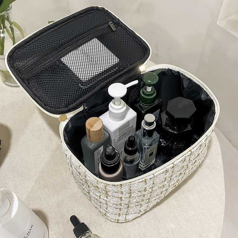 Spacious interior of Large Capacity Cosmetic Makeup Bag for Professionals, holding multiple skincare and makeup bottles with mesh pocket in lid.