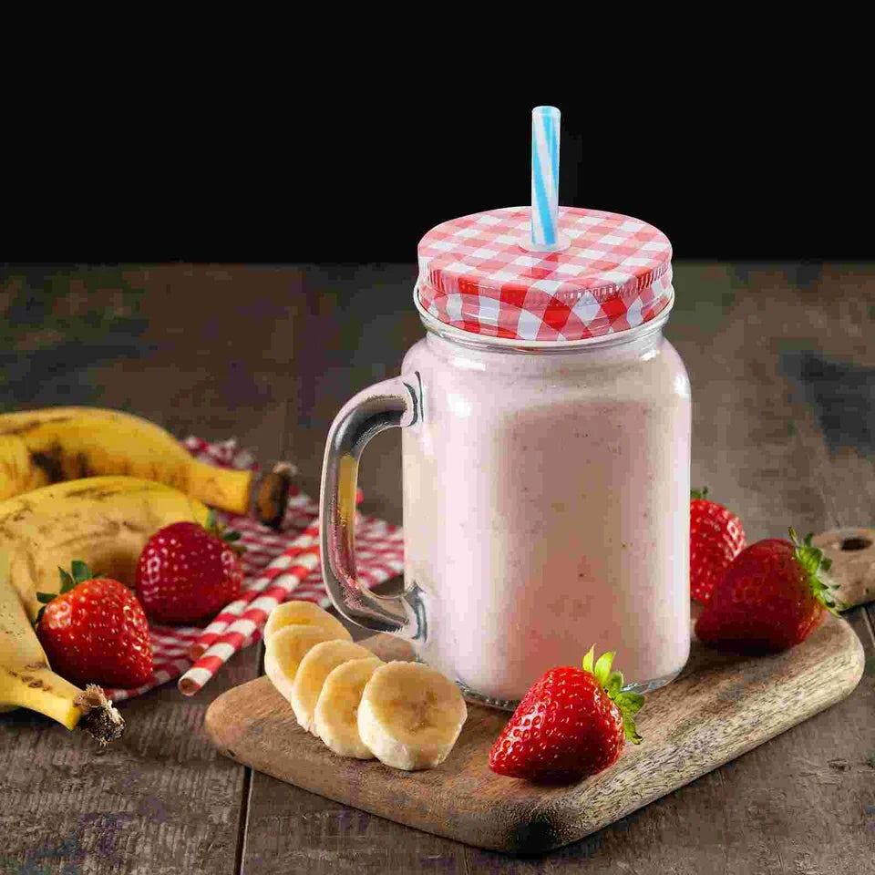 Glass Mason Jar - Durable 490ml glass jar with handle, filled with strawberry banana smoothie. Features a red gingham lid and straw, perfect for drinks.