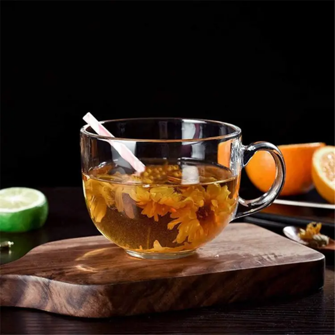 Elegant clear glass tea cup filled with herbal tea and flowers, part of the Glass Tea Cup Set 6 PCS, 150 ml from Bamagate.com