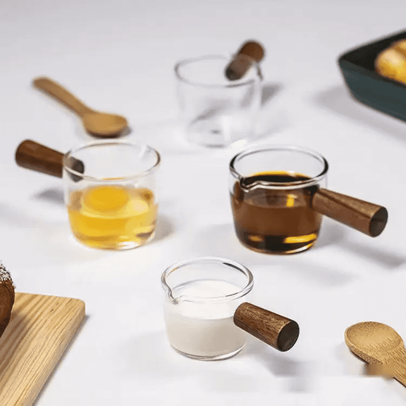 Set of 100 ml Glass Espresso Measuring Cups with wooden handles, used for measuring milk, espresso, and eggs in kitchen and dining applications.