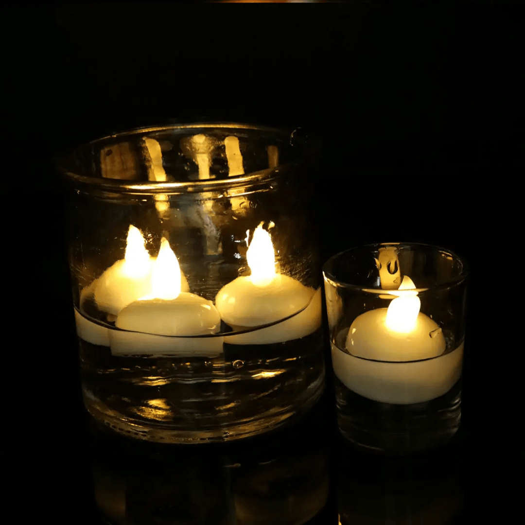 Floating LED candles glowing warmly in water-filled glass containers; perfect for ambient lighting at weddings, parties, or home decor.