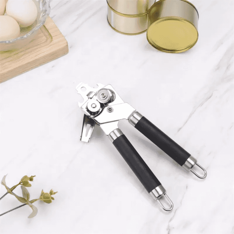 Classic Multifunction Can Opener for Kitchen placed on marble countertop with tin cans, showcasing sleek design and kitchen utility.