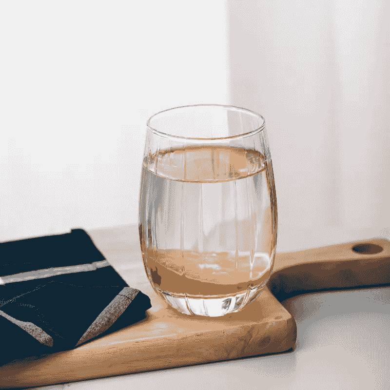 Elegant Ribbed Whisky Juice Glass filled with juice on a wooden board, showcasing its versatility and premium design for modern kitchen and dining.