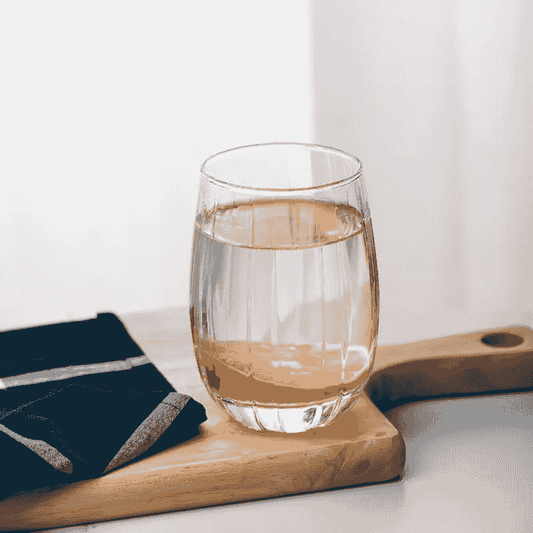 Elegant Ribbed Whisky Juice Glass filled with juice on a wooden board, showcasing its versatility and premium design for modern kitchen and dining.