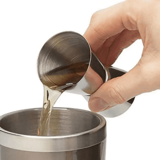 Stainless steel cocktail shaker measure cup pouring liquid into a shaker, ideal for precise bartending in Sri Lanka.