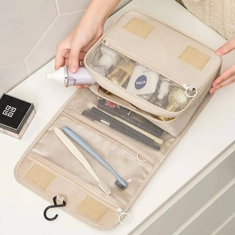 Open foldable toiletry makeup bag with mesh compartments holding toothbrush, skincare, and beauty tools. Perfect for travel and bathroom use.