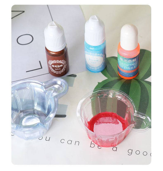 Epoxy Dispensing Cups 10 Pack shown with dye bottles and red pigment. Perfect disposable solution for hand crafting and epoxy projects.