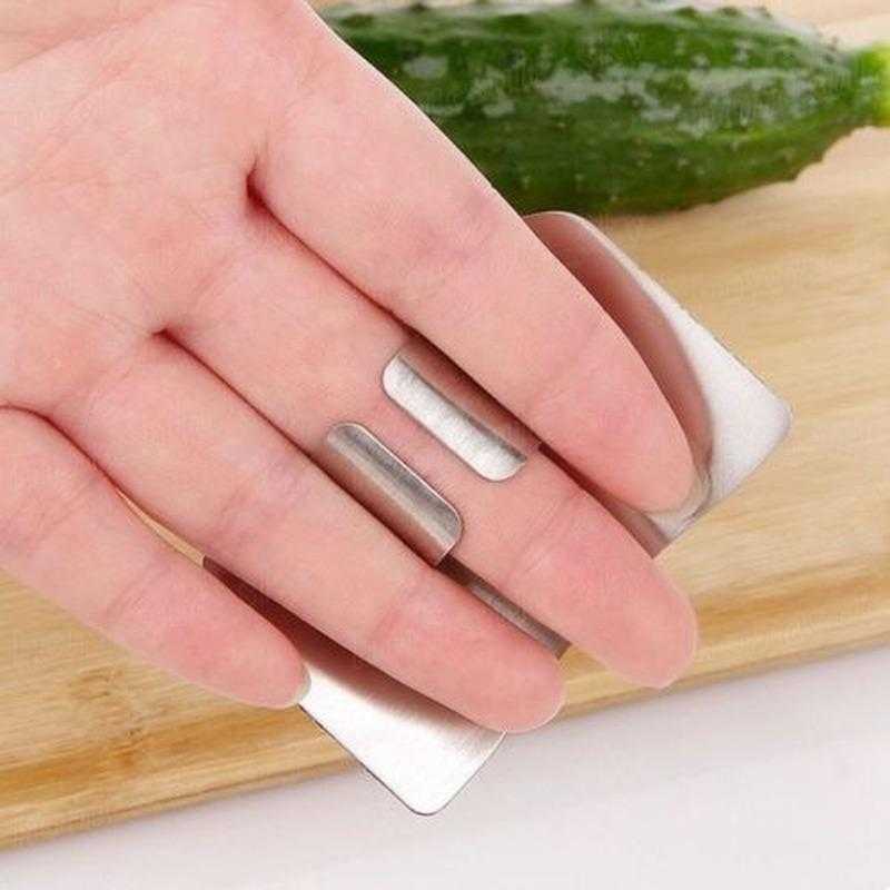 Stainless Steel Finger Guard - Safe Cutting Tool fits comfortably on fingers for protection while slicing vegetables on a cutting board.