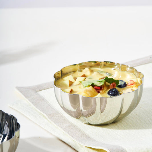 Durable 4.5" stainless steel dessert bowl filled with fruit custard, perfect for stylish dessert presentation at home or in restaurants.