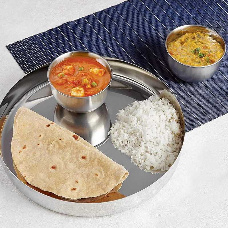 Stainless steel dinner plate 30 cm used for serving Indian meal with rice, curry, and flatbread. Perfect for home dining or casual serving.