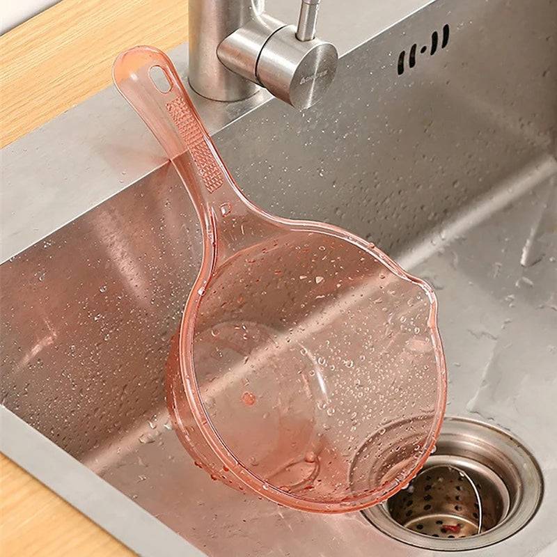 Pink transparent plastic ladle resting on a kitchen sink. Designed for easy pouring and handling, perfect for kitchen tasks.