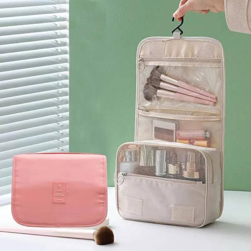 Foldable makeup bag with hanging hook, open to show organized compartments for brushes and cosmetics. Ideal travel toiletry bag for beauty essentials.