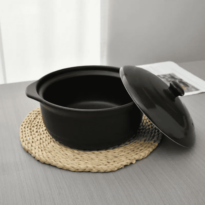 Ceramic Casserole Dish 24 cm with lid shown open on a woven mat, ideal for soups and stews in modern kitchen settings.
