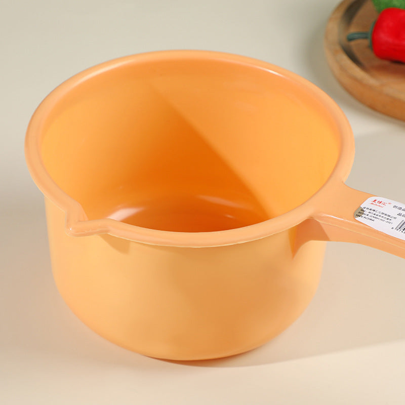 Peach-colored plastic ladle with ergonomic long handle and pouring spout, perfect for home cooking and food monitoring tasks.