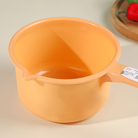 Peach-colored plastic ladle with ergonomic long handle and pouring spout, perfect for home cooking and food monitoring tasks.
