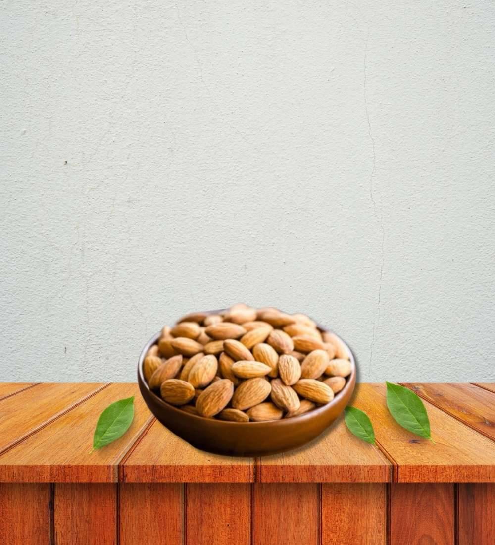 Whole raw almond nuts in a wooden bowl, rich in fiber and protein. Buy 250g of premium quality almonds, a great source of Omega-3 and essential nutrients.