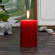 Lit Pillar Small Candle Red 3 on a wooden surface, enhancing cozy home decor. Great for mood lighting and home fragrance accents.