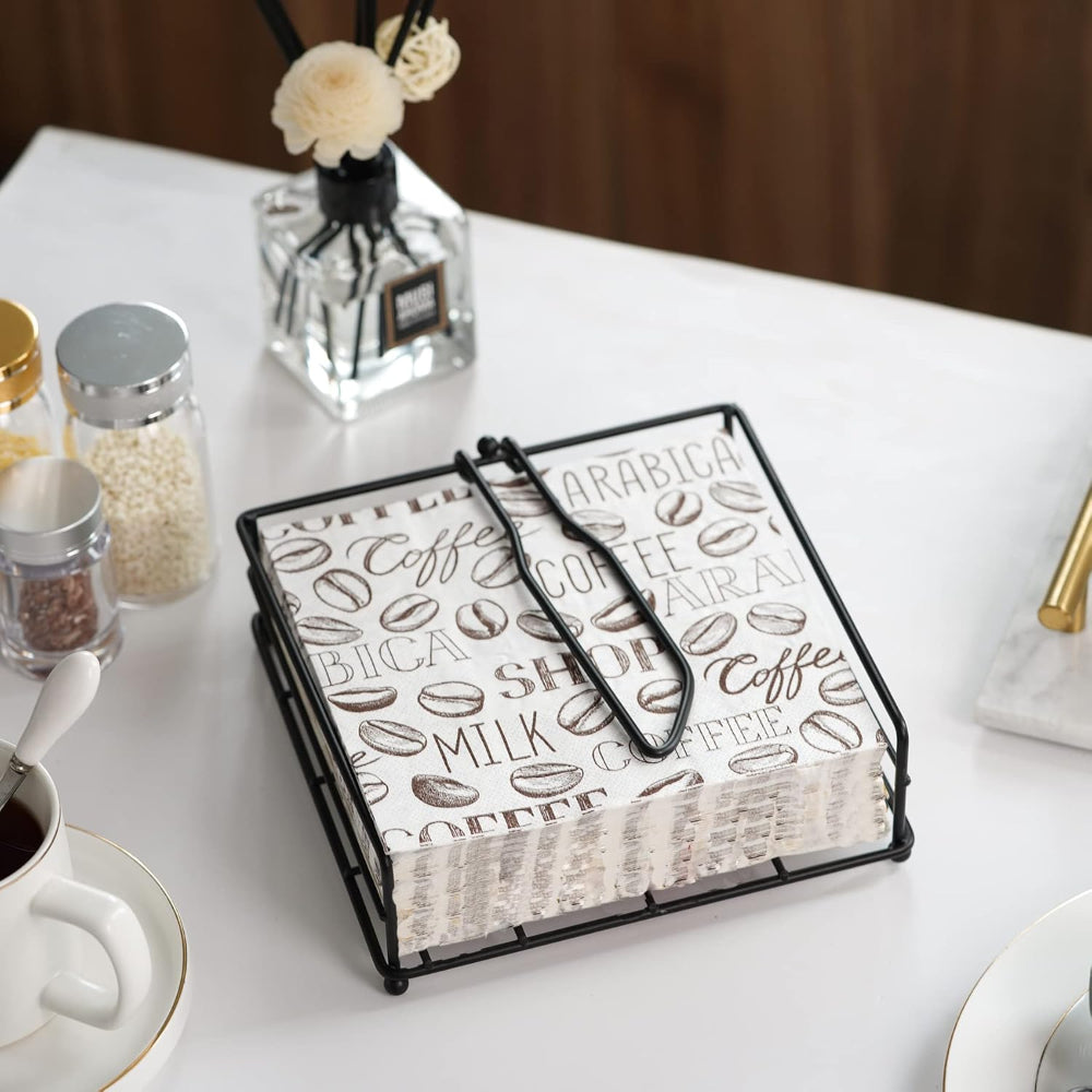Stylish black metal napkin holder on a dining table, showcasing elegant tissue storage for home and kitchen decor.