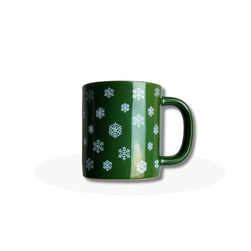 Festive Green Snowflake Ceramic Mug with white snowflake patterns, ideal for winter drinks. 325 ml capacity, perfect for gifting in Sri Lanka.