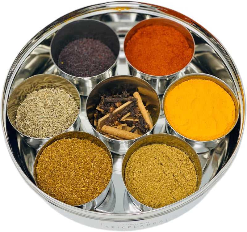 Stainless Steel Masala Box Set filled with 7 spices including turmeric and cumin, perfect spice storage for home kitchens.