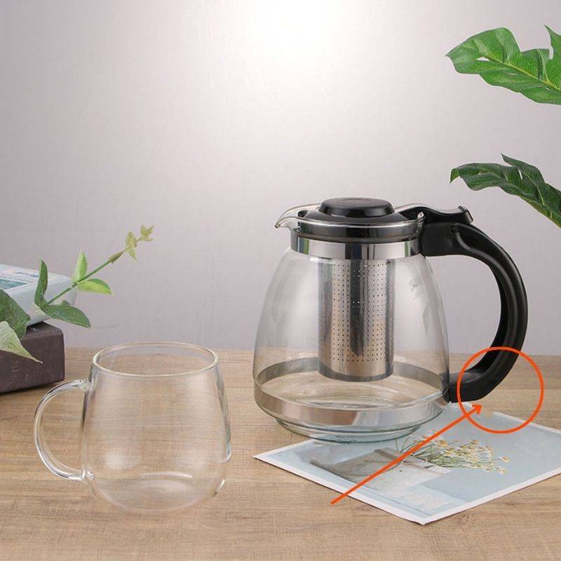 Glass Teapot 700ml with Infuser and ergonomic black handle, shown with matching glass cup on wooden table. Ideal for 2-cup tea brewing at home.