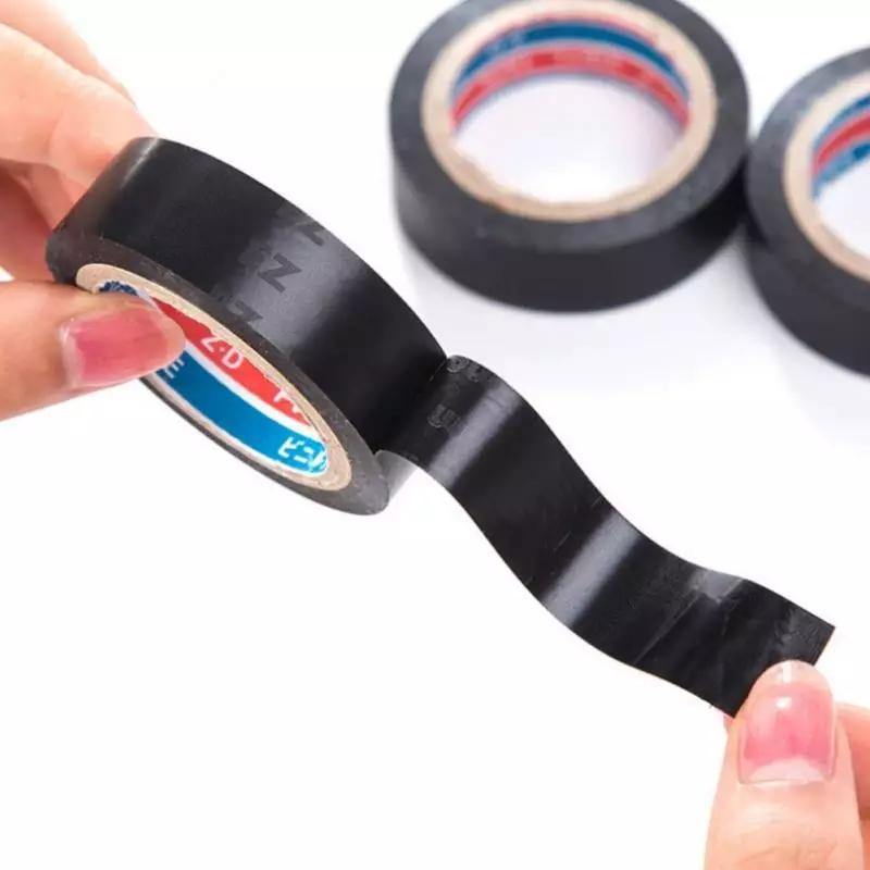 Close-up of hands pulling black electrical insulation tape from roll, showcasing flexibility and adhesive strength. Buy insulation tape at Bamagate.com.