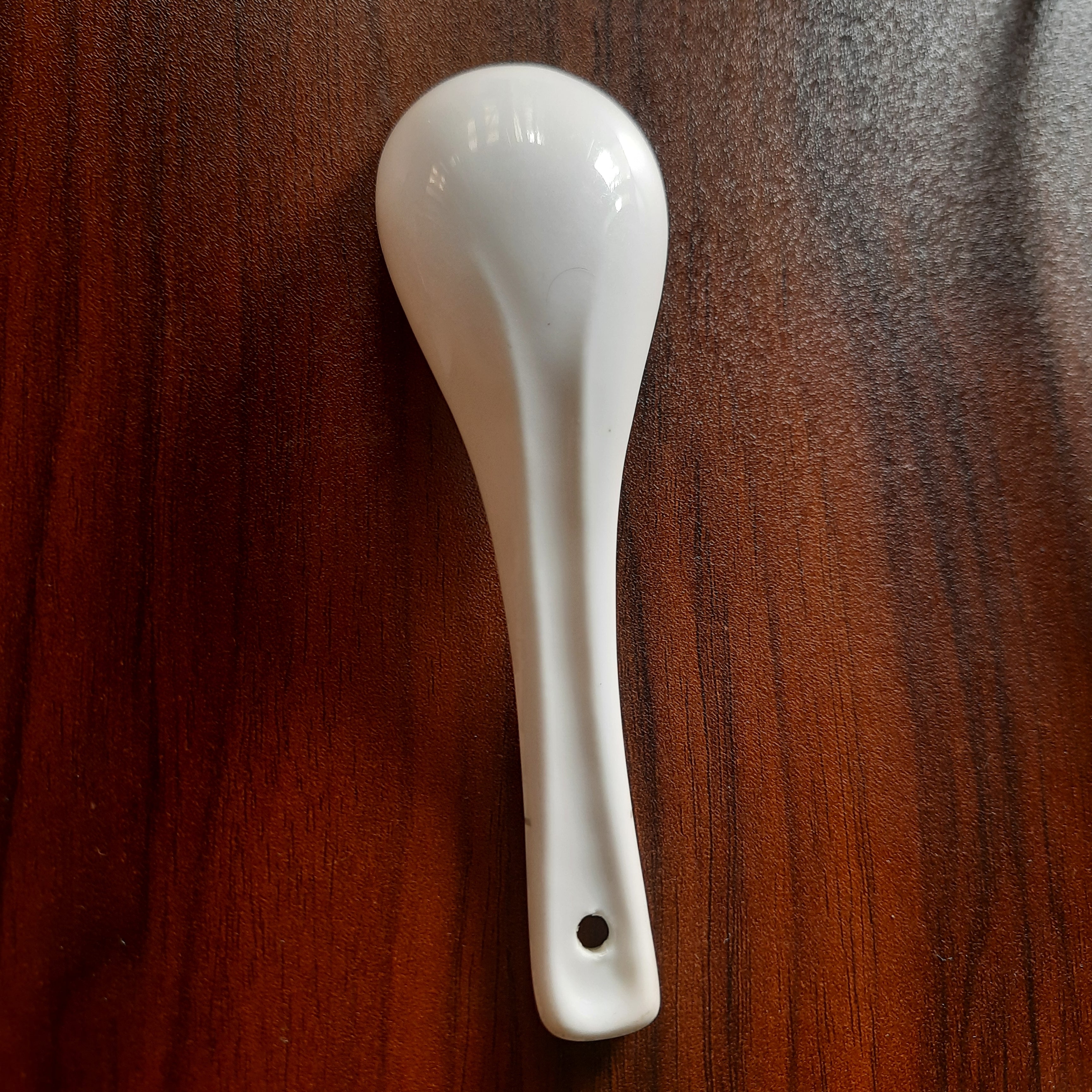 White Melamine Soup Spoon - Dishwasher Safe | 6x2 inches displayed on a dark wood surface, durable and suitable for everyday kitchen use.