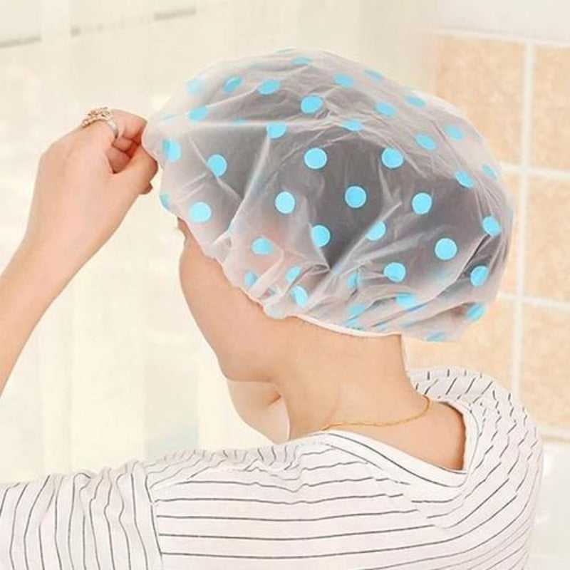 Shower cap waterproof protection with blue polka dots, worn by a person in a bathroom setting. Ideal for keeping hair dry during showers.