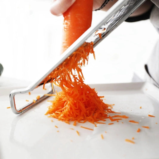 Hand using Stainless Steel Flat Vegetable Grater to shred carrots finely, efficient kitchen tool available at Bamagate.com