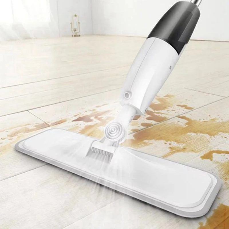 White Healthy Spray Mop spraying water on stained wooden floor, showcasing powerful cleaning action with microfiber pad.