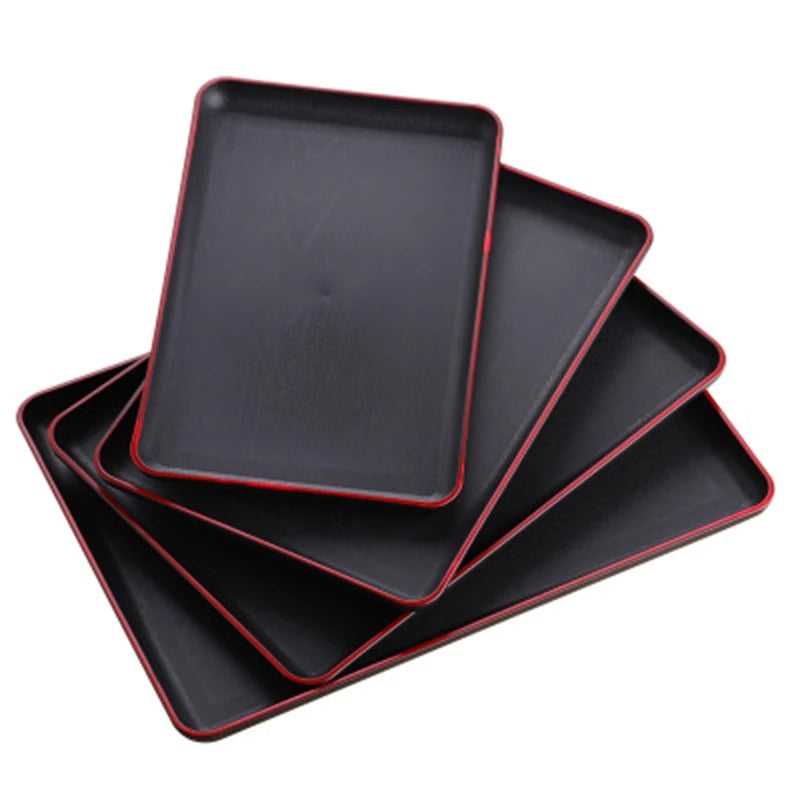 Stack of rectangular plastic serving trays with black surface and red edge finish, ideal for kitchen and dining use. Available at best price in Sri Lanka on Bamagate.com.