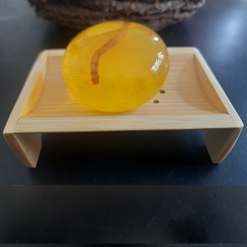 Bamboo Soap Dish - Eco Friendly Design holding a round amber soap. Stylish and sustainable bathroom accessory from Bamagate.com.